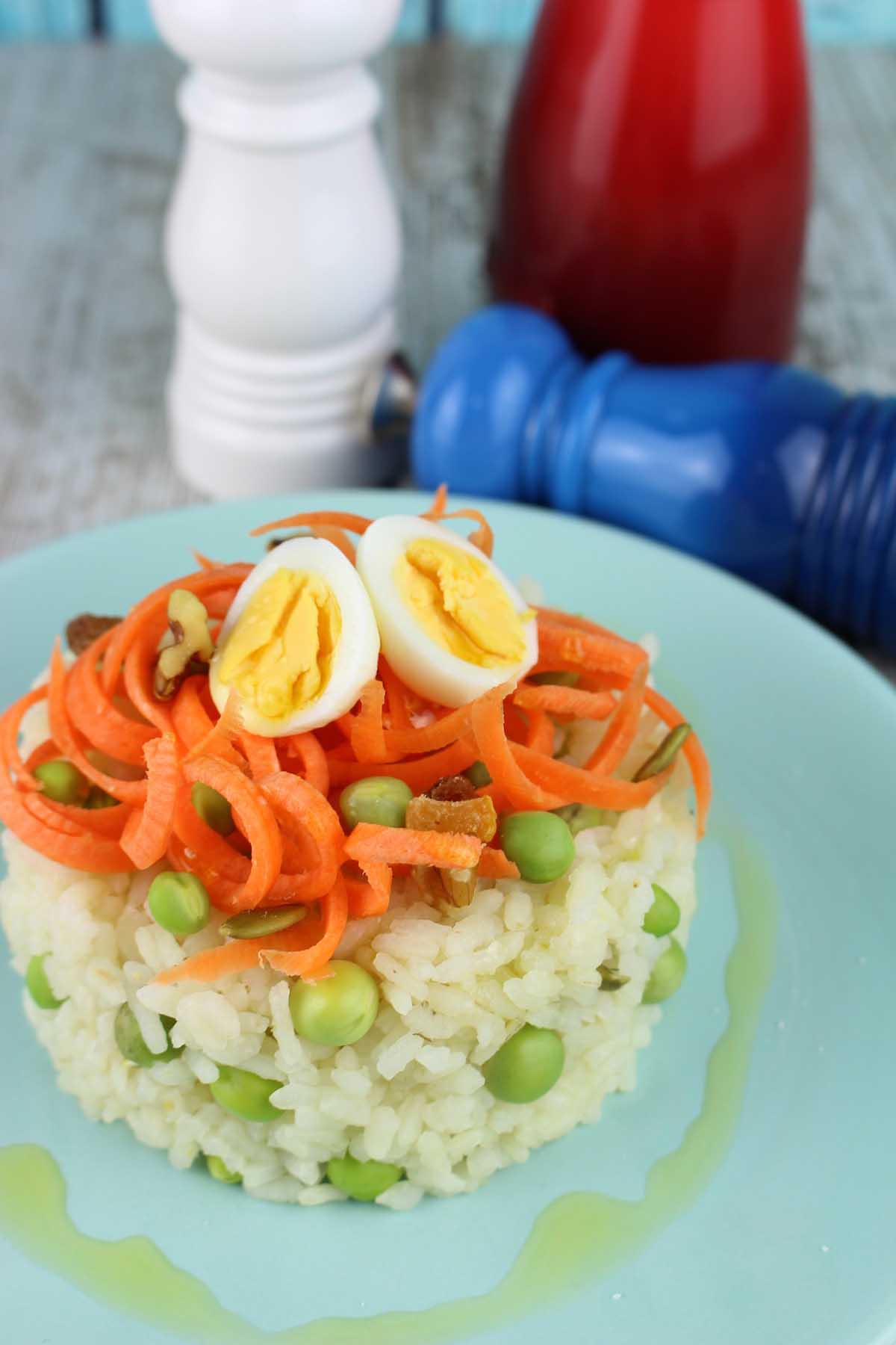 Ensalada de arroz con zanahorias, guisantes frescos y huevos de codorniz